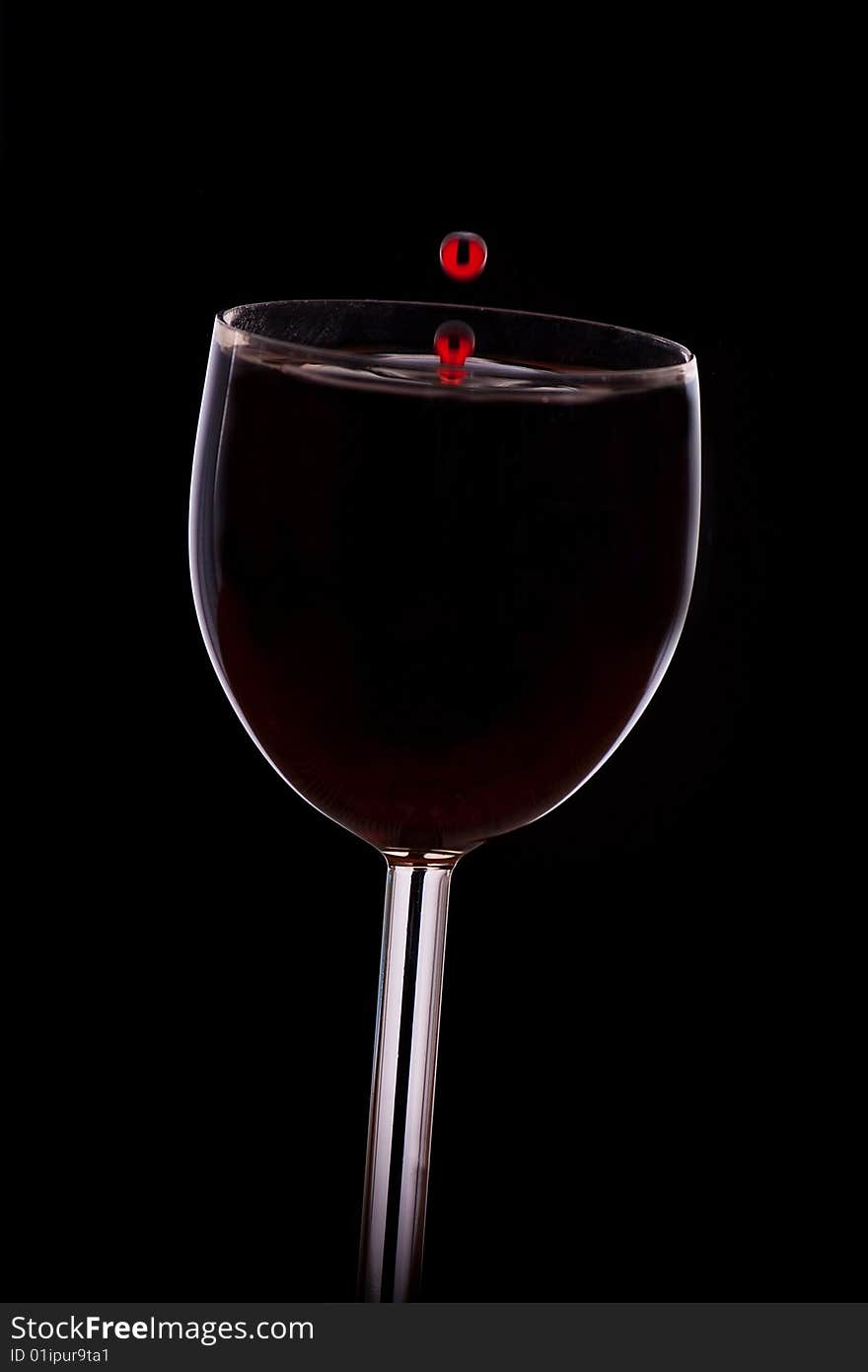 A Drop Of Red Wine Falls Into The Glass