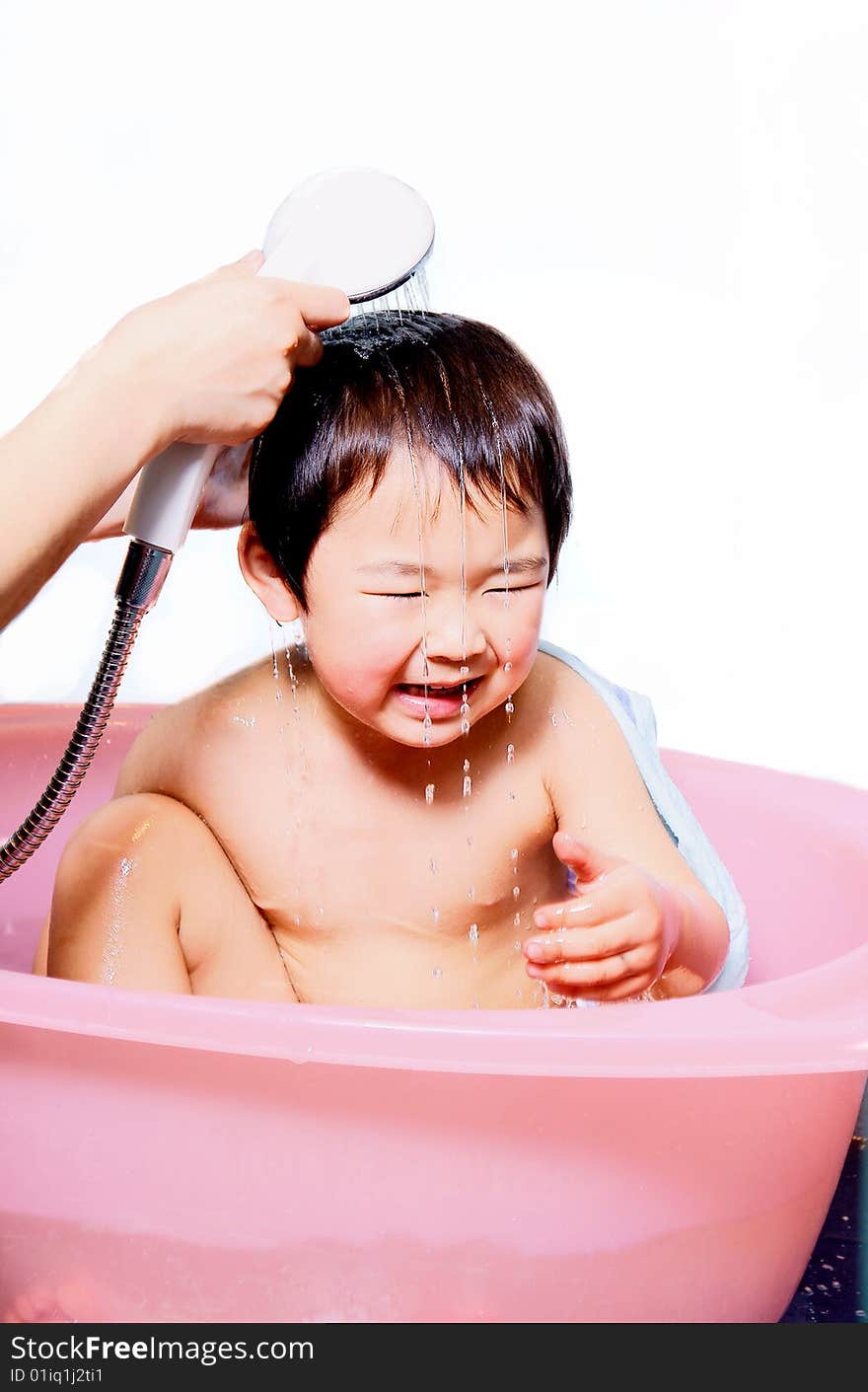 A picture of a little chinese boy taking bath and playing with water happily. A picture of a little chinese boy taking bath and playing with water happily