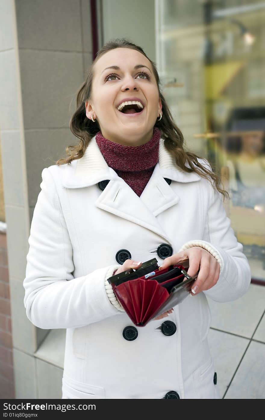 Woman with the empty wallet near shop shopwindow. Woman with the empty wallet near shop shopwindow