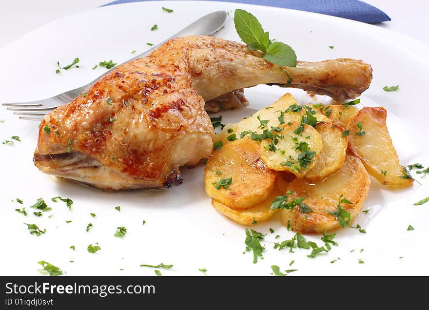 Grilled chicken leg with potato and parsley