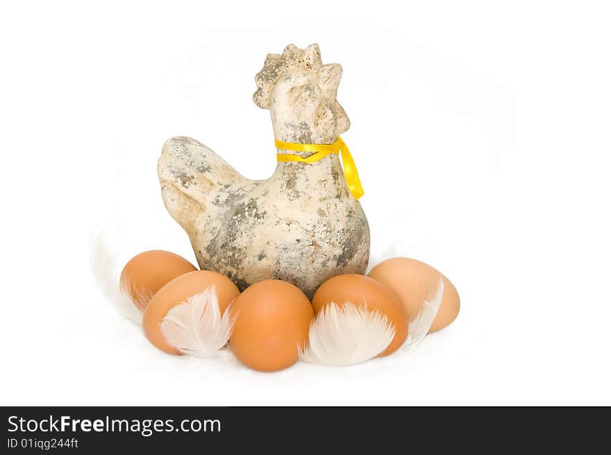 An ceramic chicken with real brown eggs between white feathers. An ceramic chicken with real brown eggs between white feathers