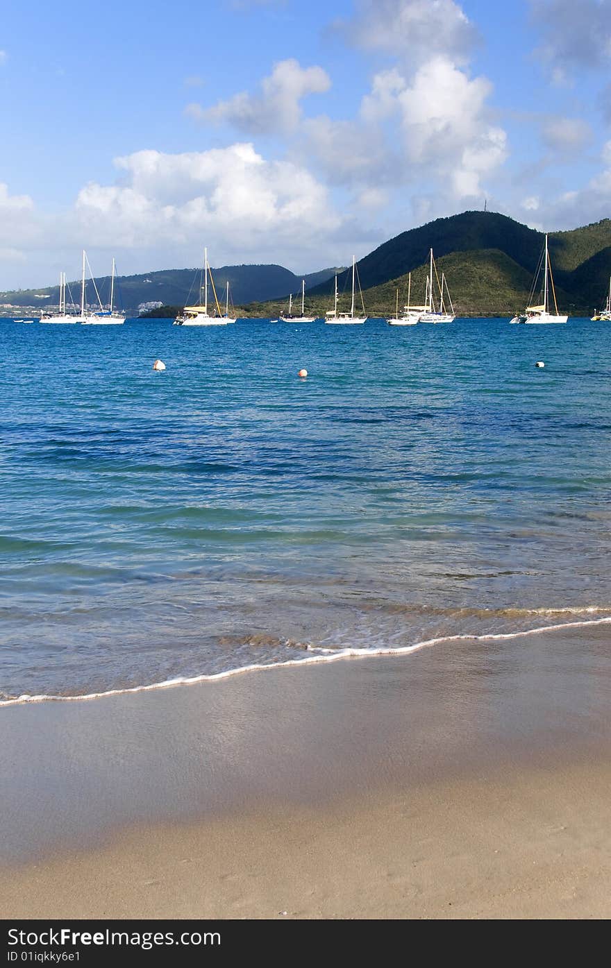 Beach with sailing ships in a tropical island