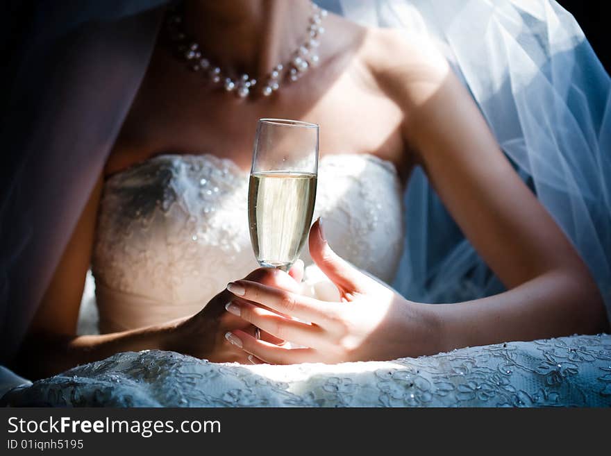 Bride with glass of champagne in the limosine