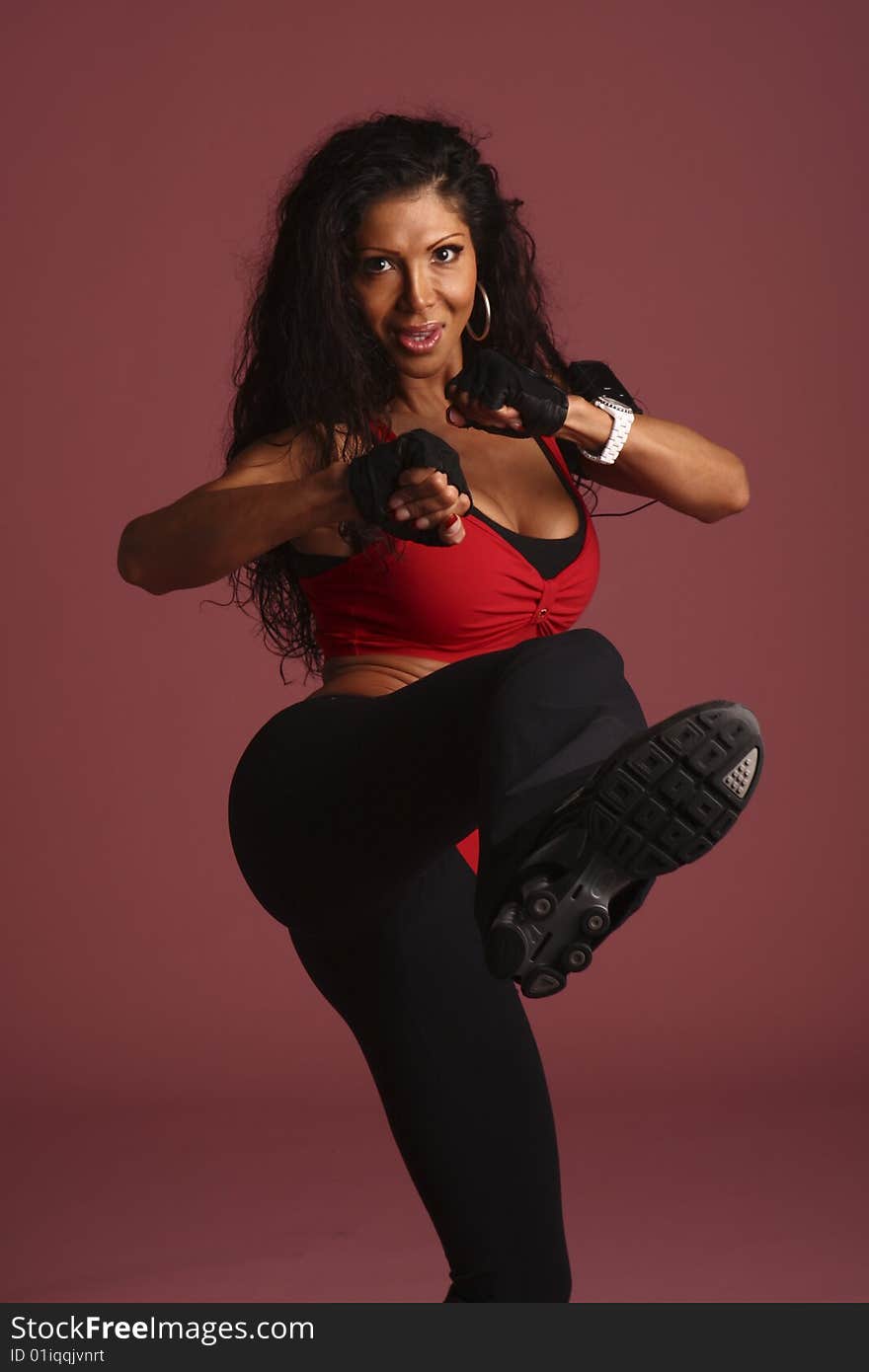 A fitness model  with long flowing hair in studio  wearing a blue, white, and black workout outfit with  gloves and ear rings. A fitness model  with long flowing hair in studio  wearing a blue, white, and black workout outfit with  gloves and ear rings.