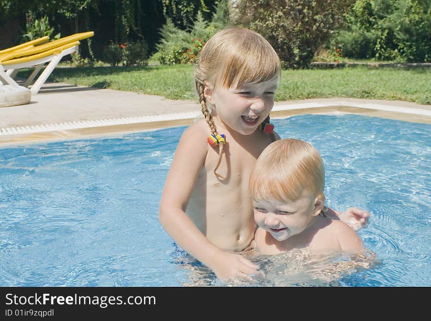 Two pretty little girls have a fun in children`s swimming-pool. Two pretty little girls have a fun in children`s swimming-pool