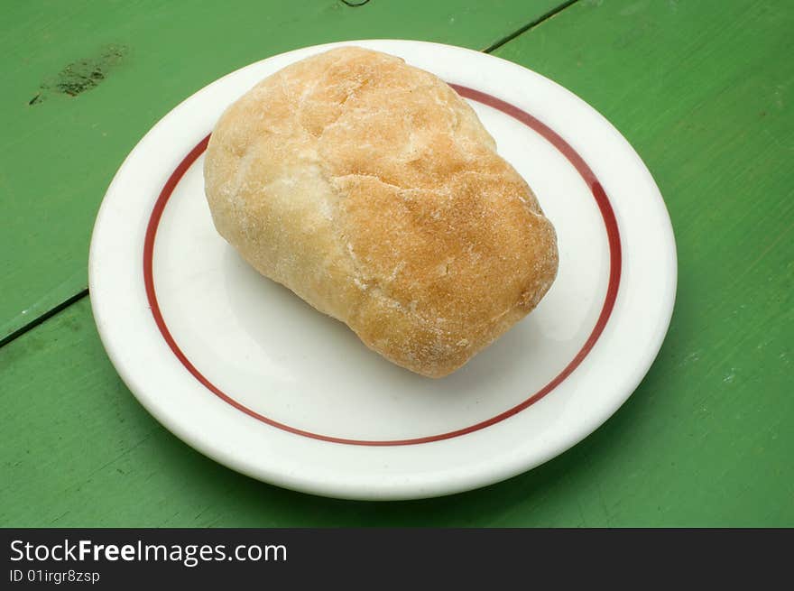 A dinner roll on a white plate