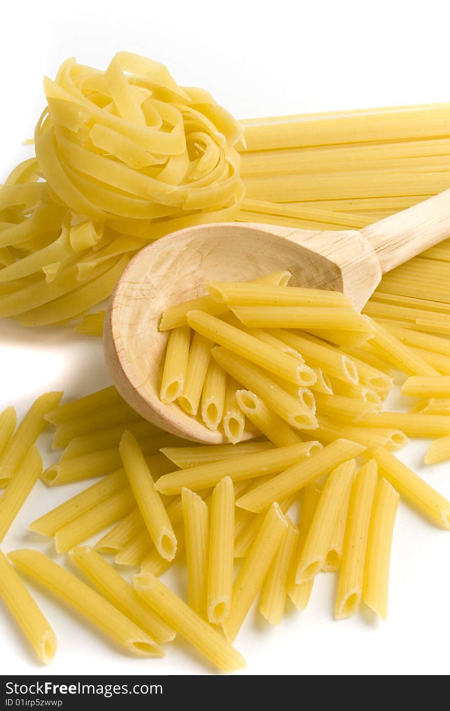 Raw italian pasta in wooden spoon on white background