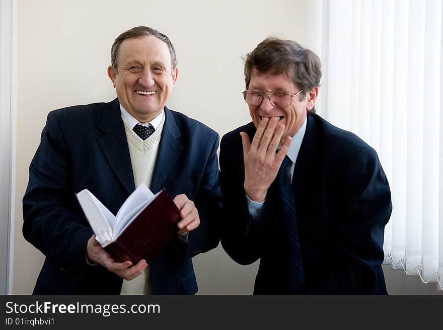 Portrait of a two senior businessmen reading the book