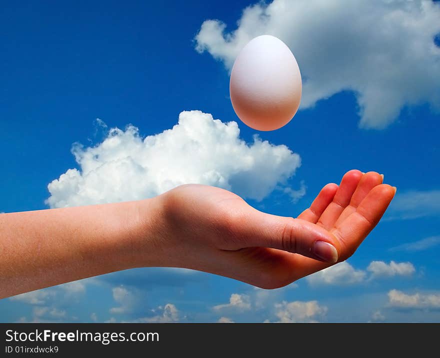 Women hand with egg on sky background with clipping path