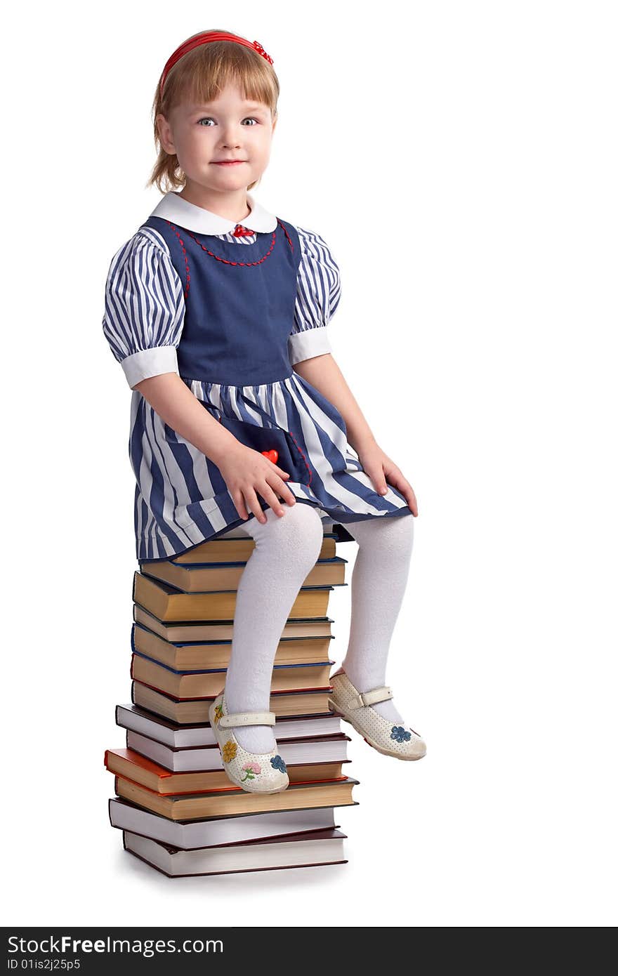 Schoolgirl sitting on the heap of books  on white background