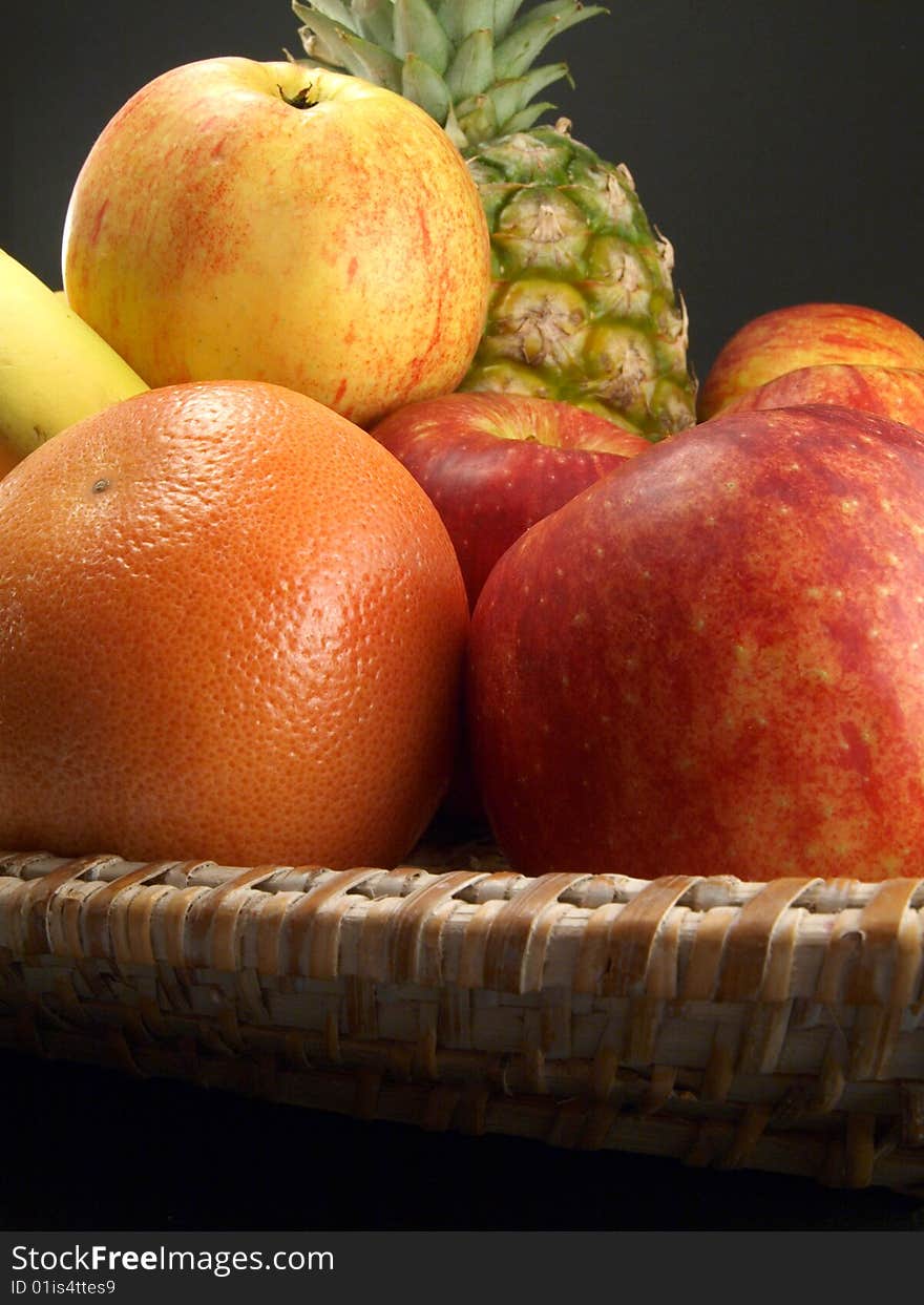 Fresh fruit in a basket on a black background. Fresh fruit in a basket on a black background.