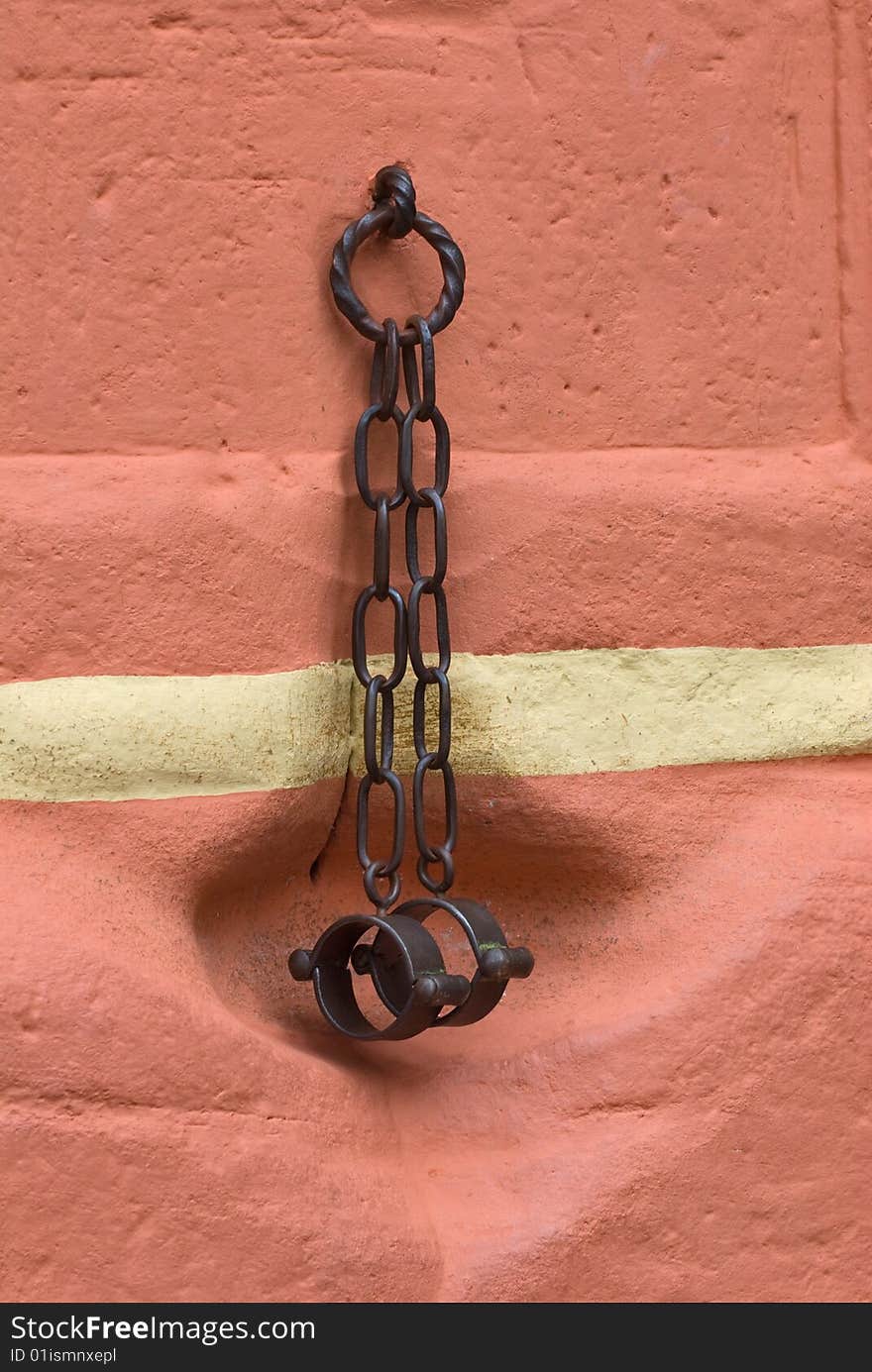 Black handcuffs on a red wall