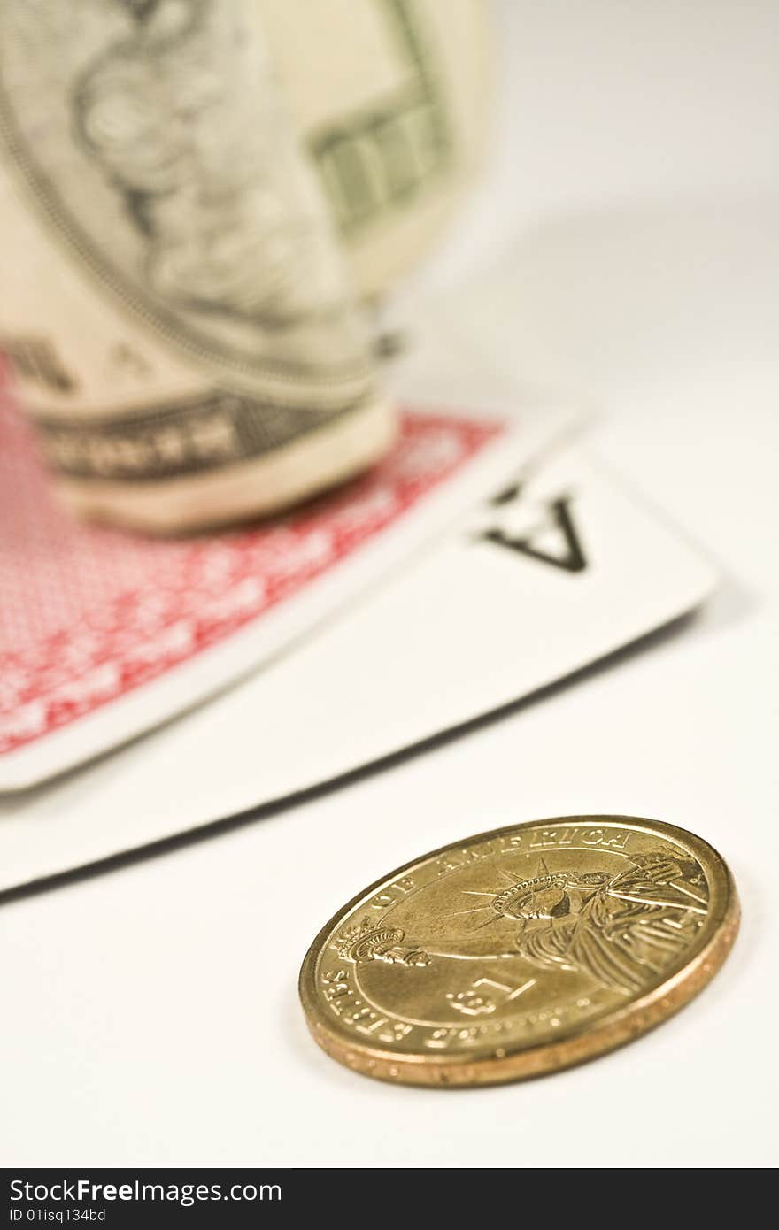 Dollar bill and coin with pair of cards isolated on a white background