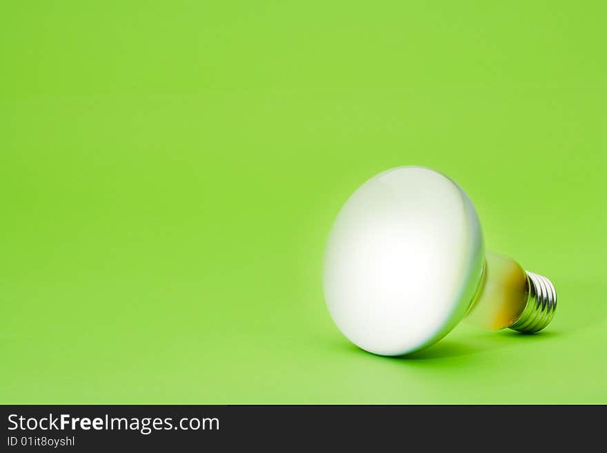 Light bulb spotlight on green background