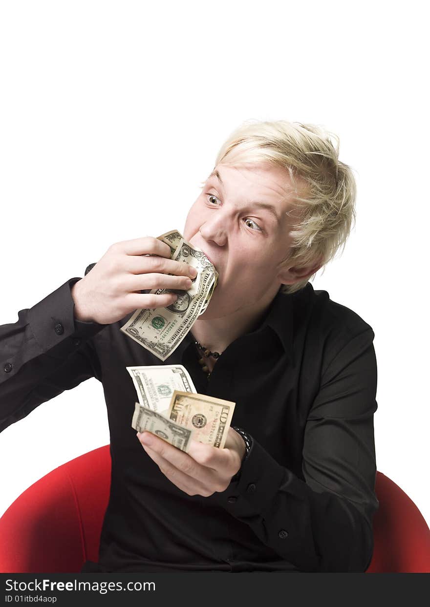 Boy eating money sitting in a chair