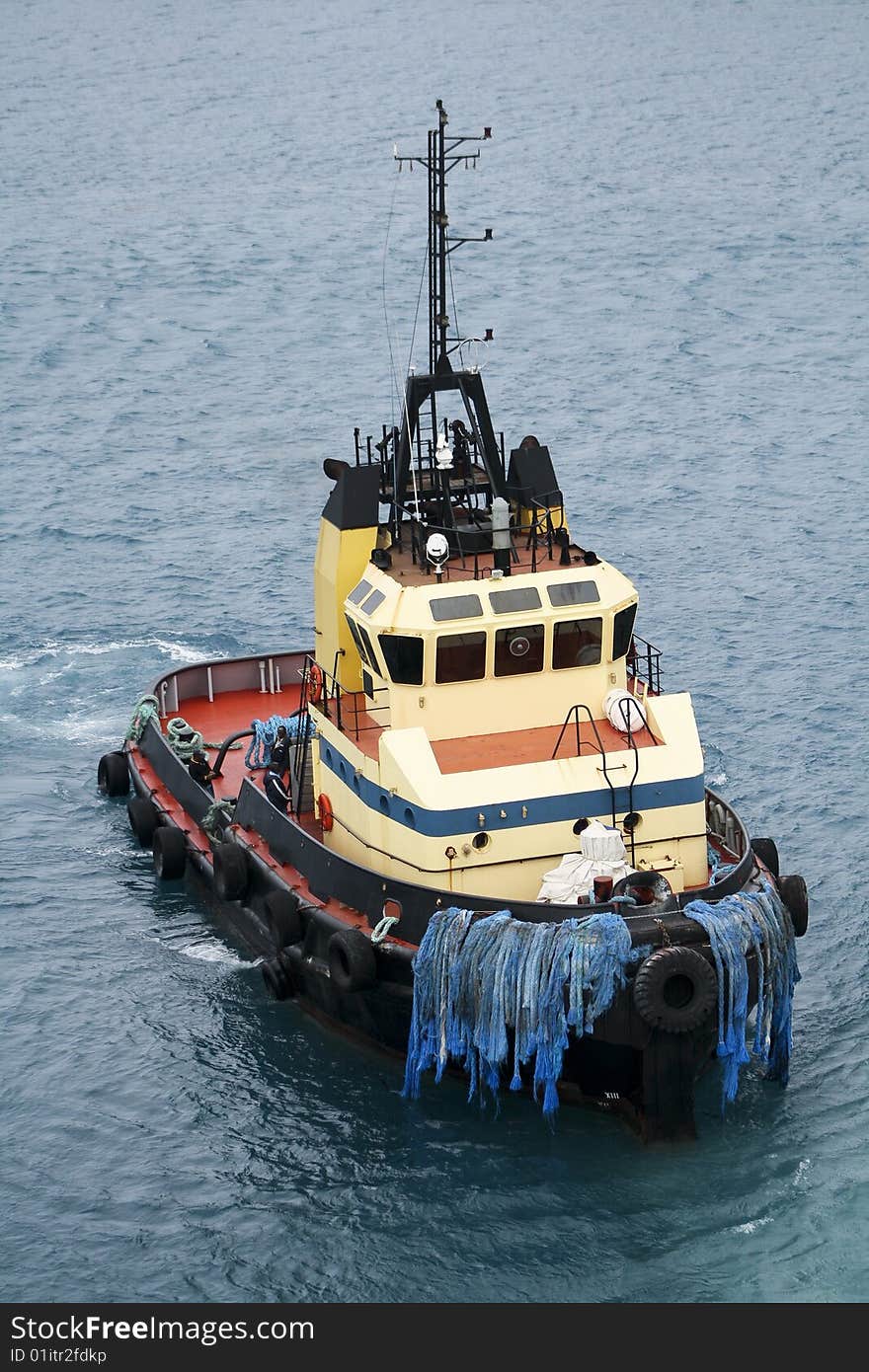 A tugboat at work getting ready to assist a cruise ship in docking. A tugboat at work getting ready to assist a cruise ship in docking