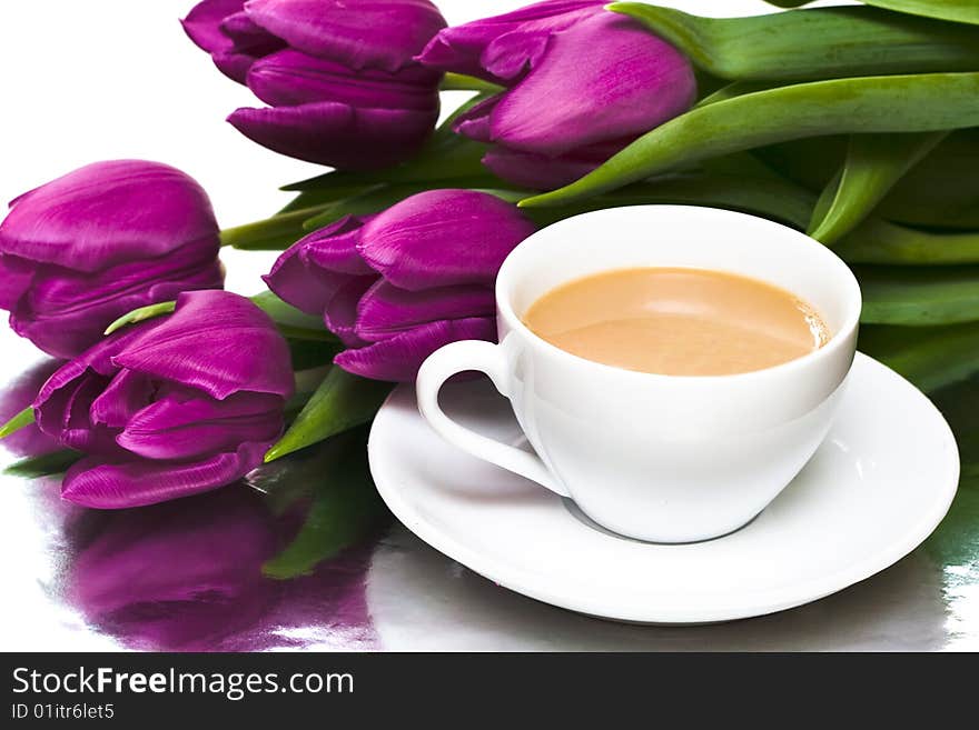 White cup of coffee with violet tulips