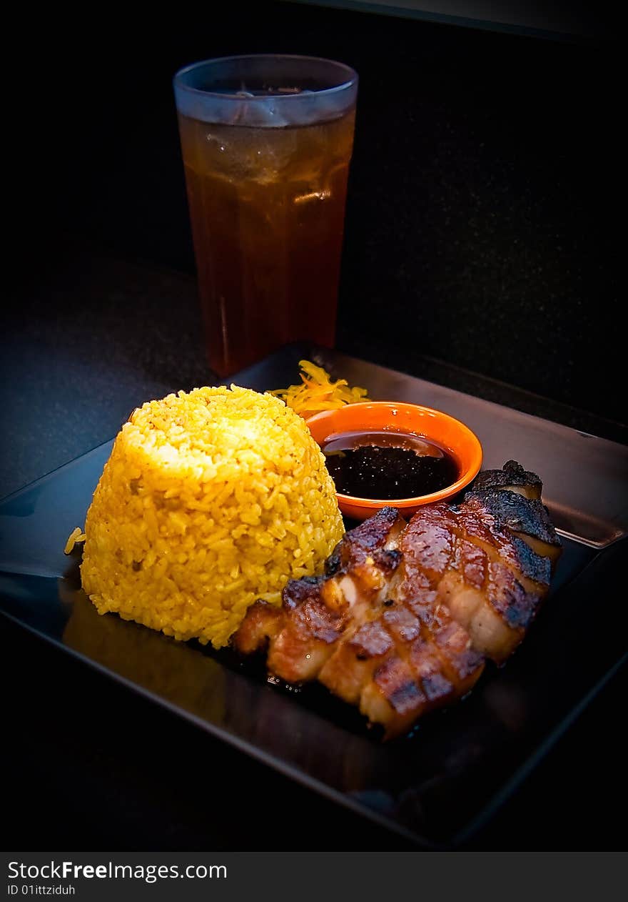 A roasted pork meal with Iced tea. A roasted pork meal with Iced tea