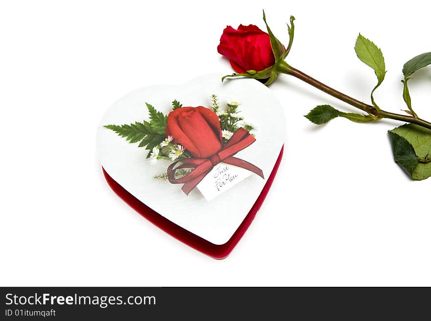 Valentine's Day candy in a heart shaped box with a red rose. Valentine's Day candy in a heart shaped box with a red rose