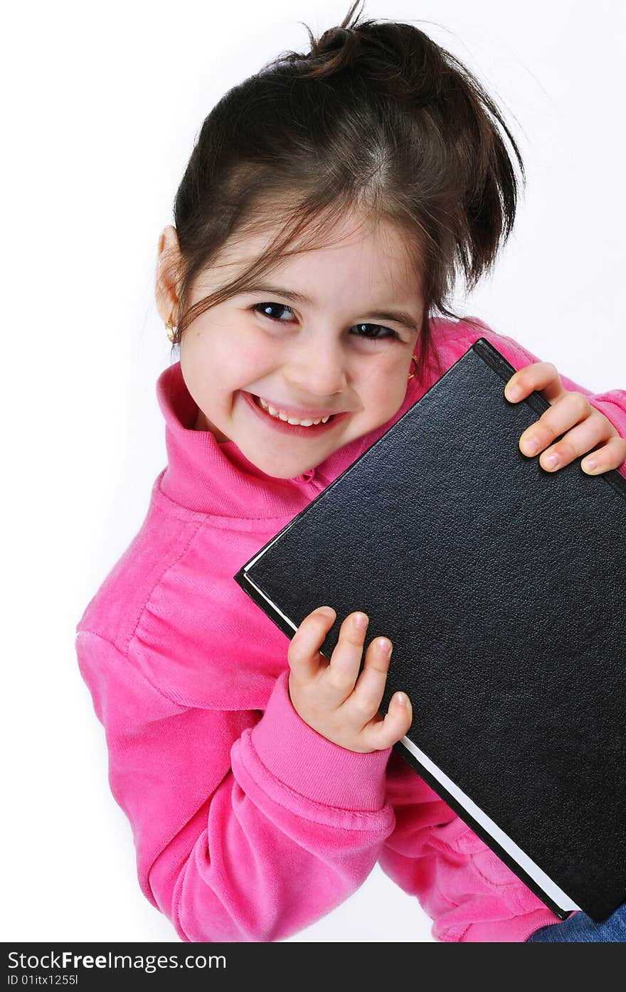 Young schoolgirl in the classroom with a book. Young schoolgirl in the classroom with a book