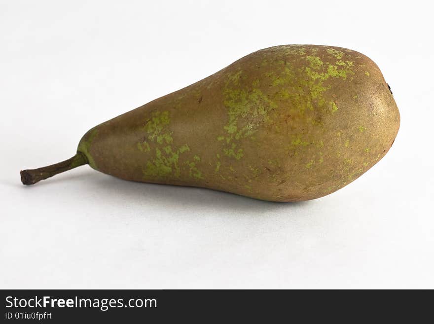 A juicy green conference pear against a white background