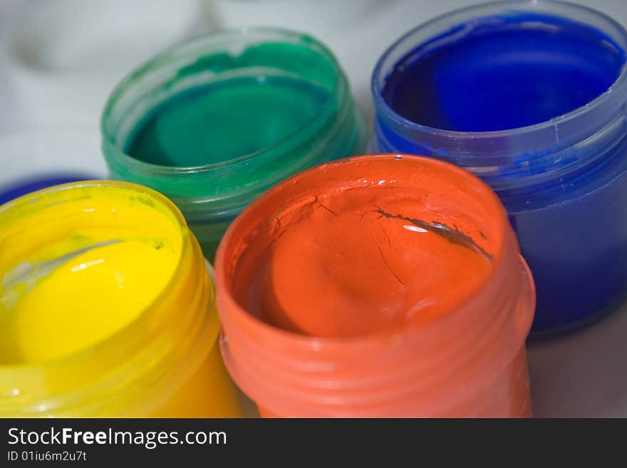 Close-up  of multicolor gouache paints. Red, yellow, dark blue and green colors. Close-up  of multicolor gouache paints. Red, yellow, dark blue and green colors.