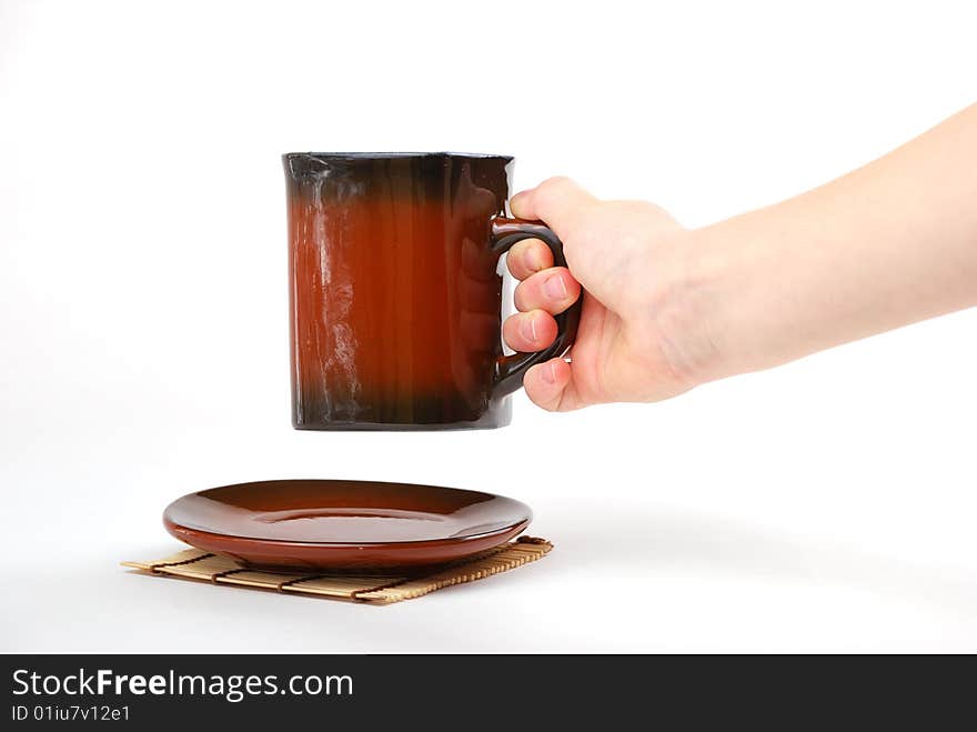 Brown cups for tea and coffee. A small white teapot. Brown cups for tea and coffee. A small white teapot.