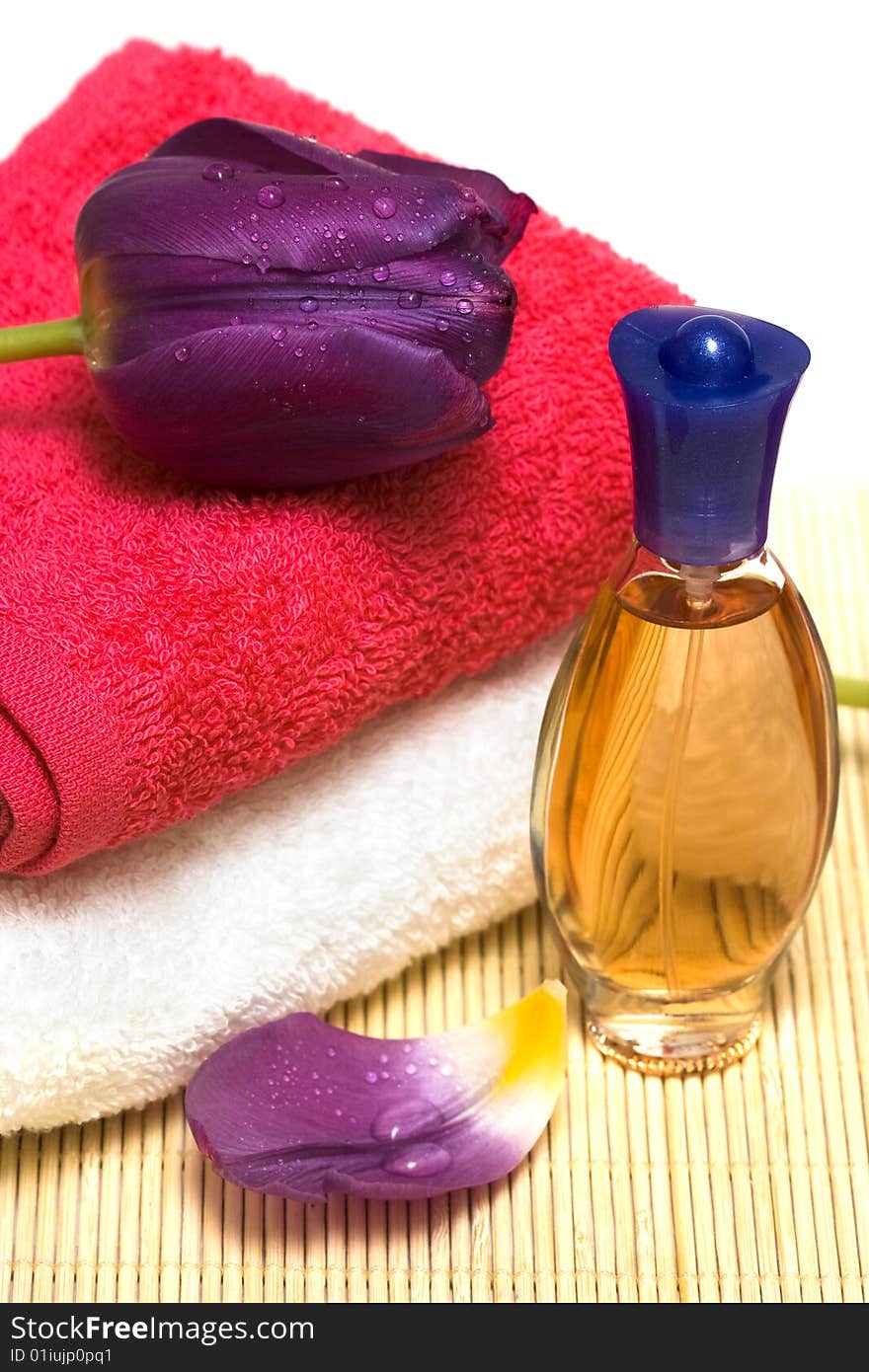 Bottle with perfume and violet tulips