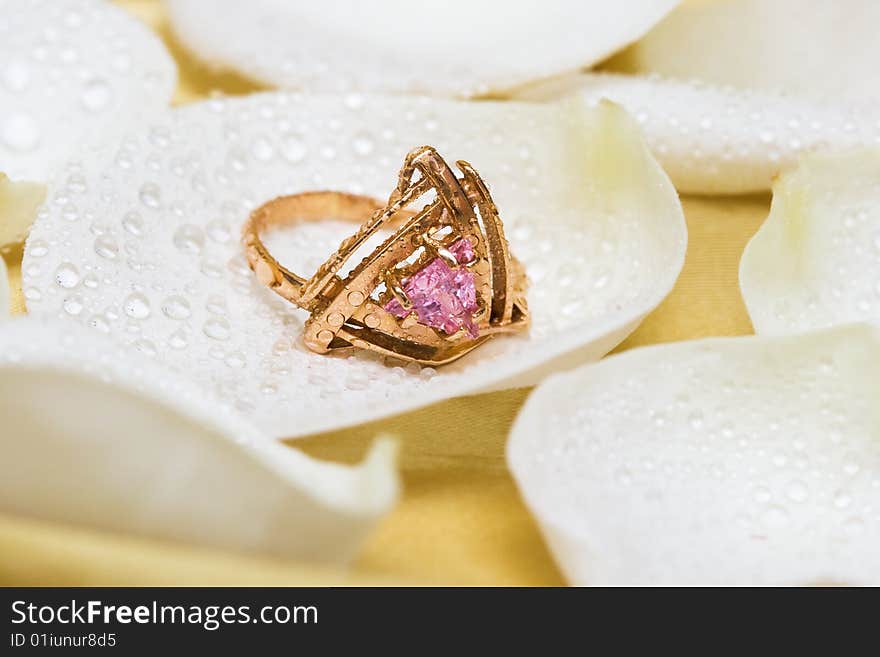 Golden ring with rose petals