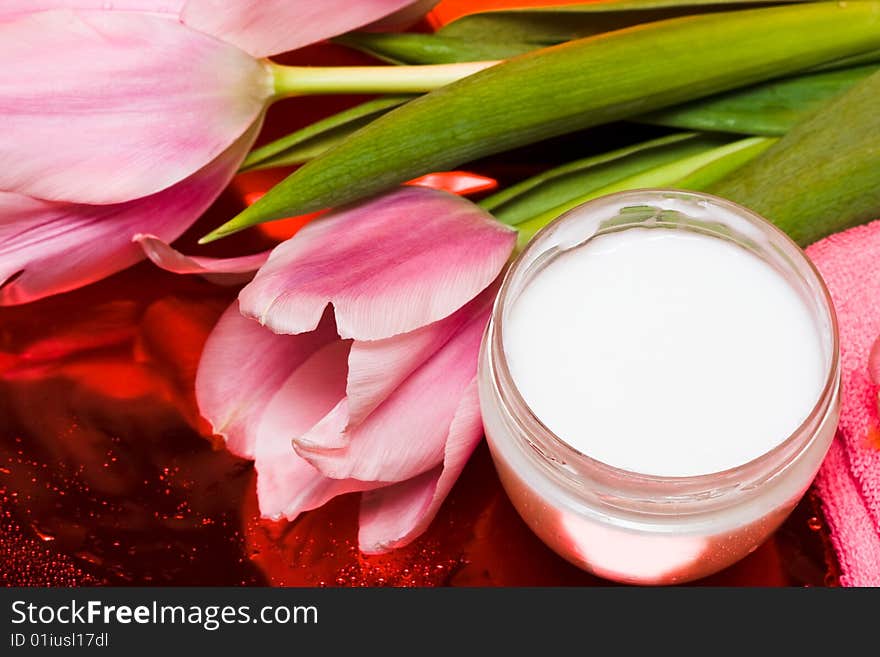 Cream, towel with flowers on red background