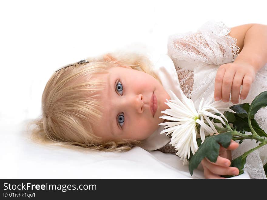 Beautiful girl lies on a white flower in his hand