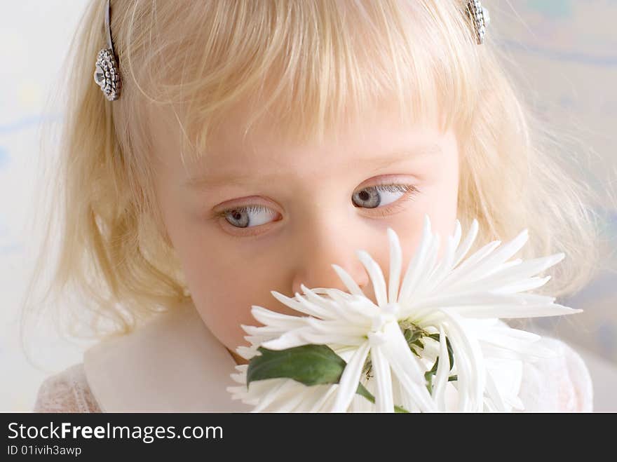 Little beautiful girl sniffing a flower