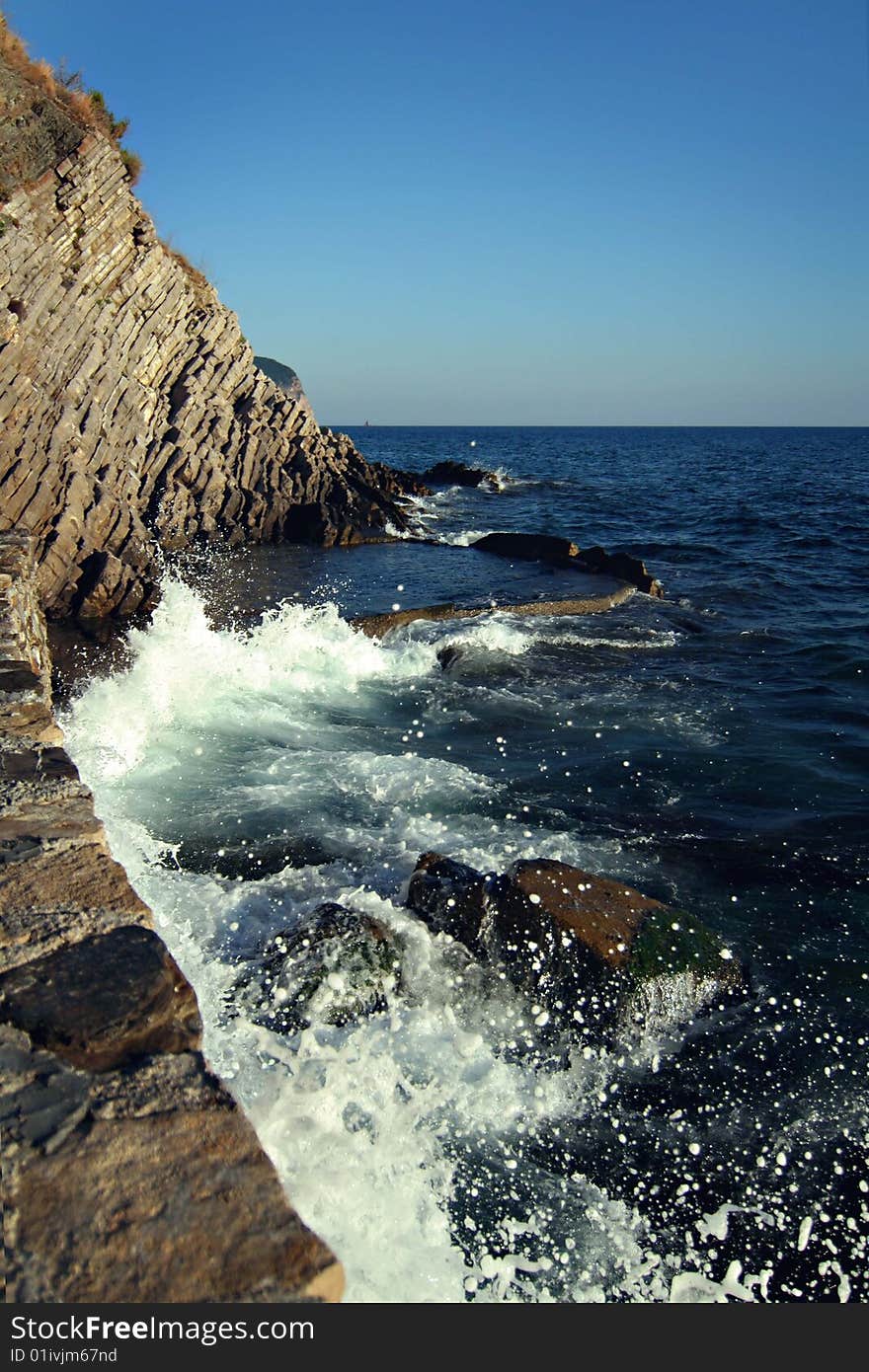 White sea-foam and rocks at sunny day