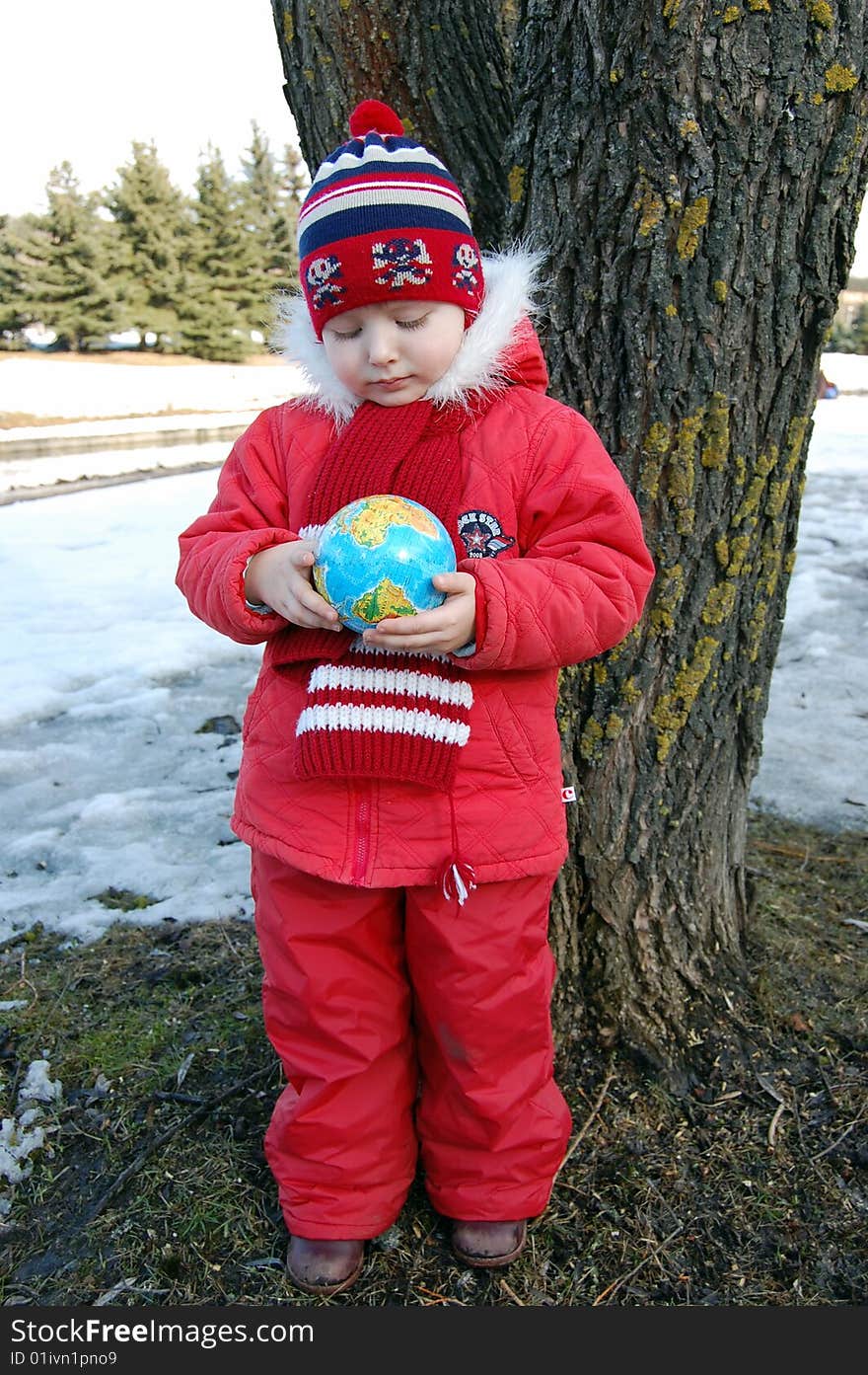 Little girl with a terrestrial globe in park near tree. Little girl with a terrestrial globe in park near tree