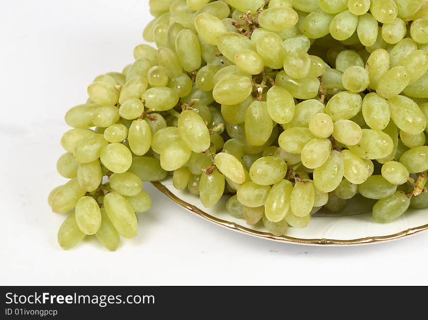 Fresh bunch of green grapes in white bowl and isolated on white background