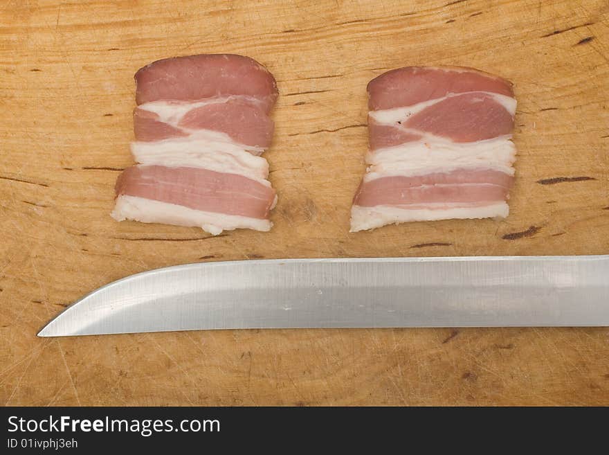 Bits of bacon and knife on chopping board