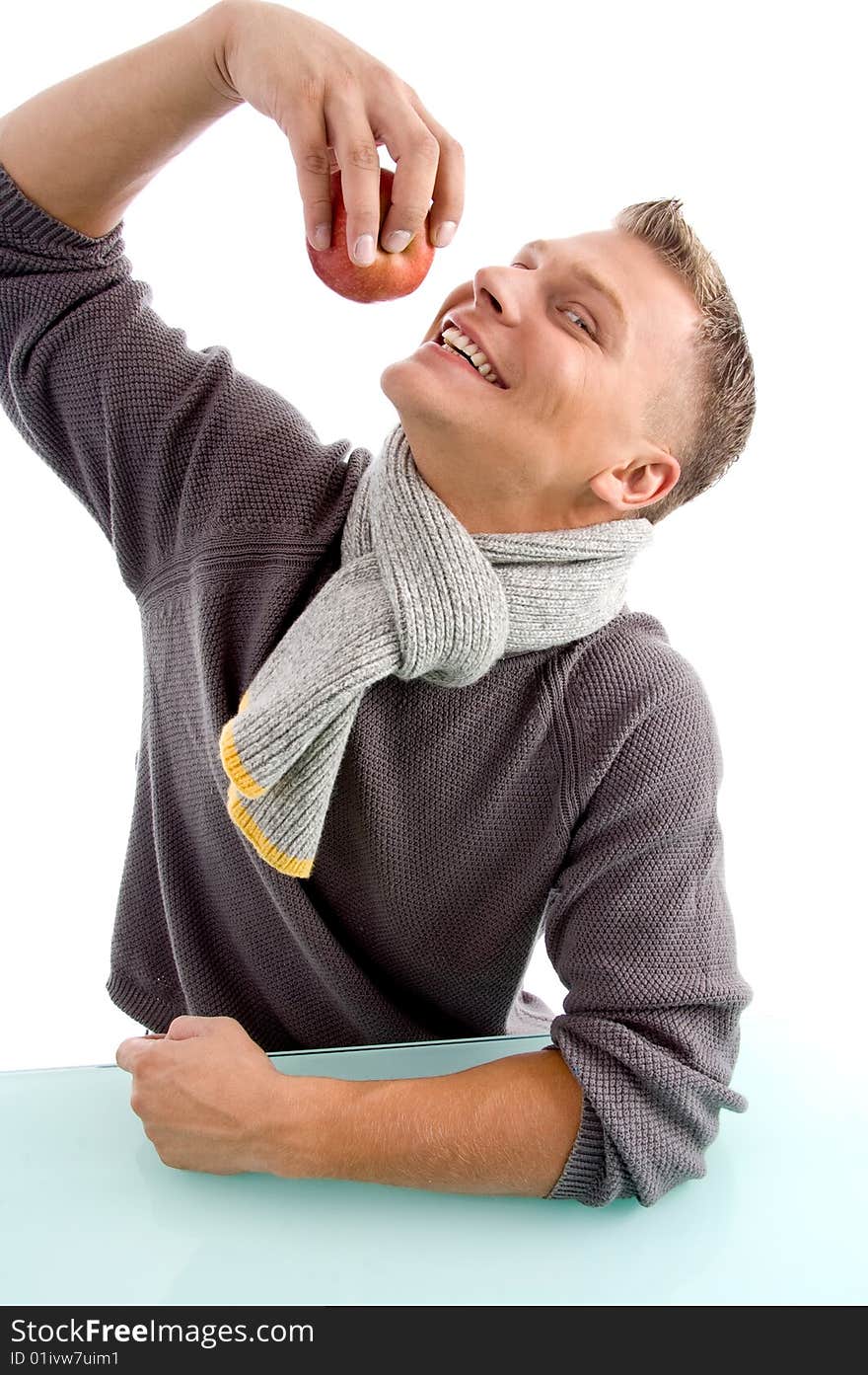 Smiling young man going to eat apple against white background