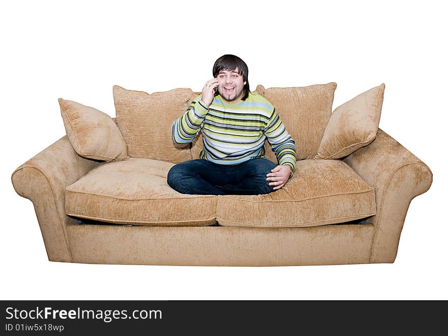 Happy young man talking and smiling on the cell phone sitting on the sofa. Happy young man talking and smiling on the cell phone sitting on the sofa