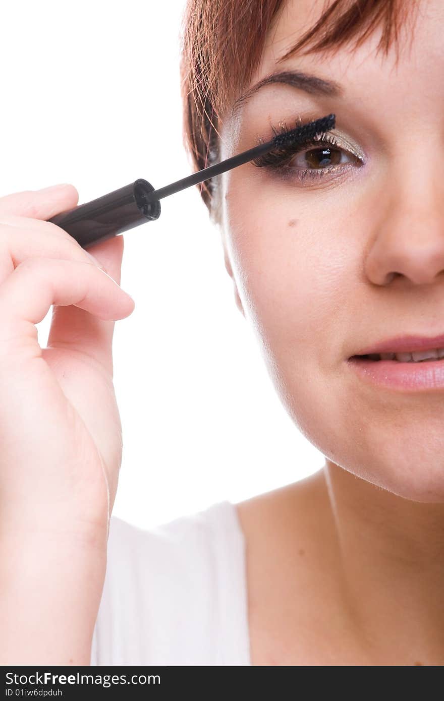 Attractive woman doing makeup. over white background