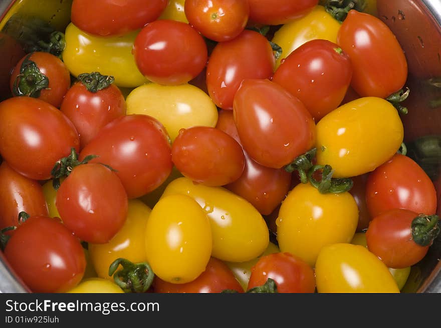 Two colours of tomatoes--red and yellow, are in the metal basin. Quite beautiful.