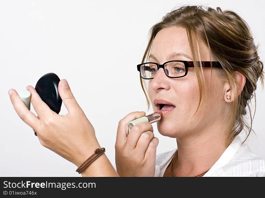 Modern woman putting on lipstick. Modern woman putting on lipstick