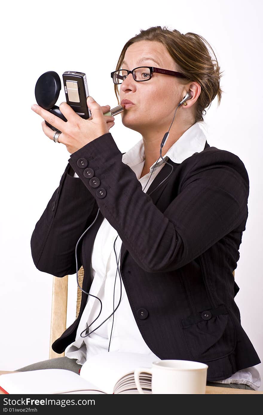 Busy businesswoman putting on make-up and talking in phone