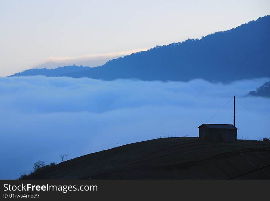 Mountain, forest and cloud. There is a ranch on the hillside. Mountain, forest and cloud. There is a ranch on the hillside.