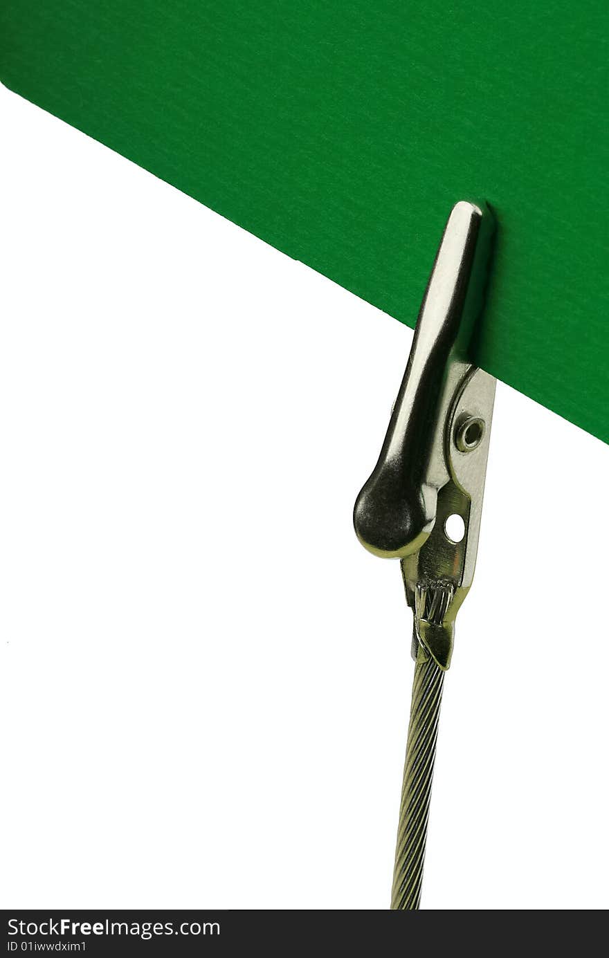 Metal clip holding a green card