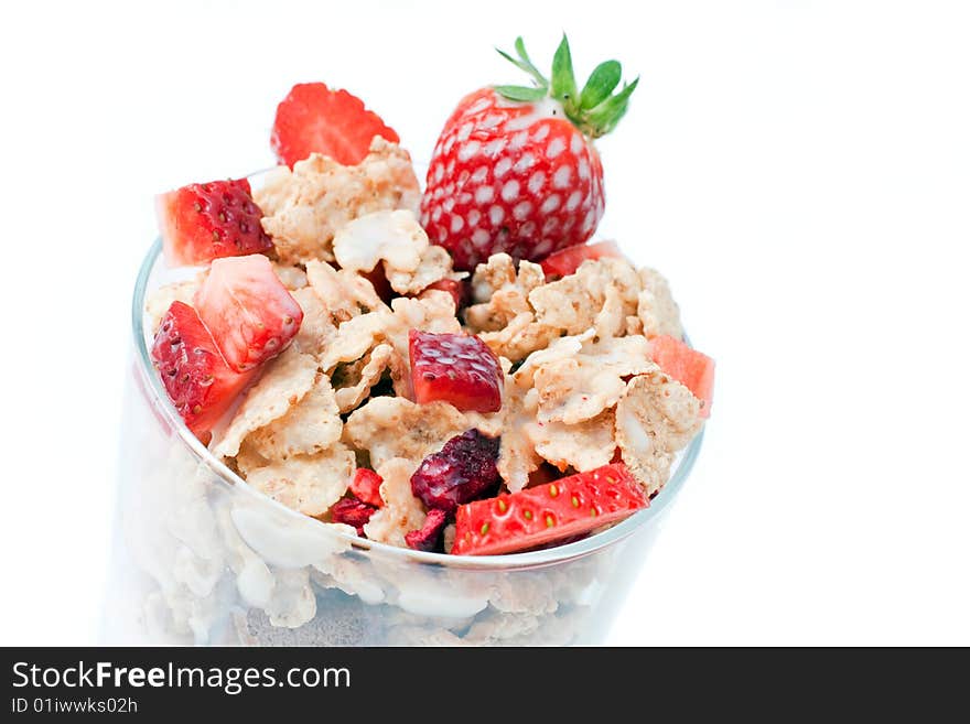 Bowl with corn flakes and strawberry served on glass