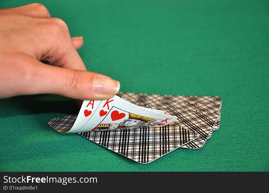 Women hand check the playing cards on a green table. Women hand check the playing cards on a green table