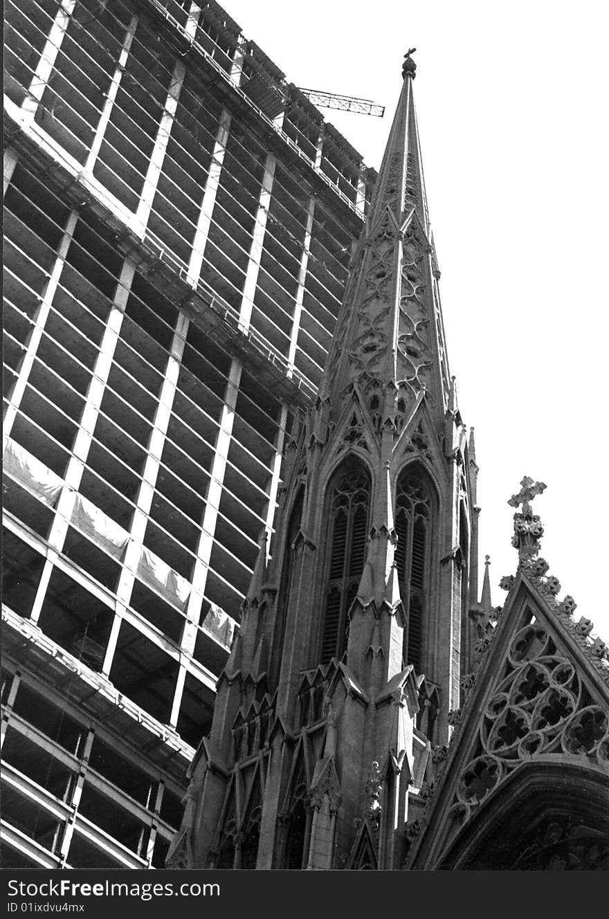 A cathedral competes for the sky with a skyscraper going up. A cathedral competes for the sky with a skyscraper going up.