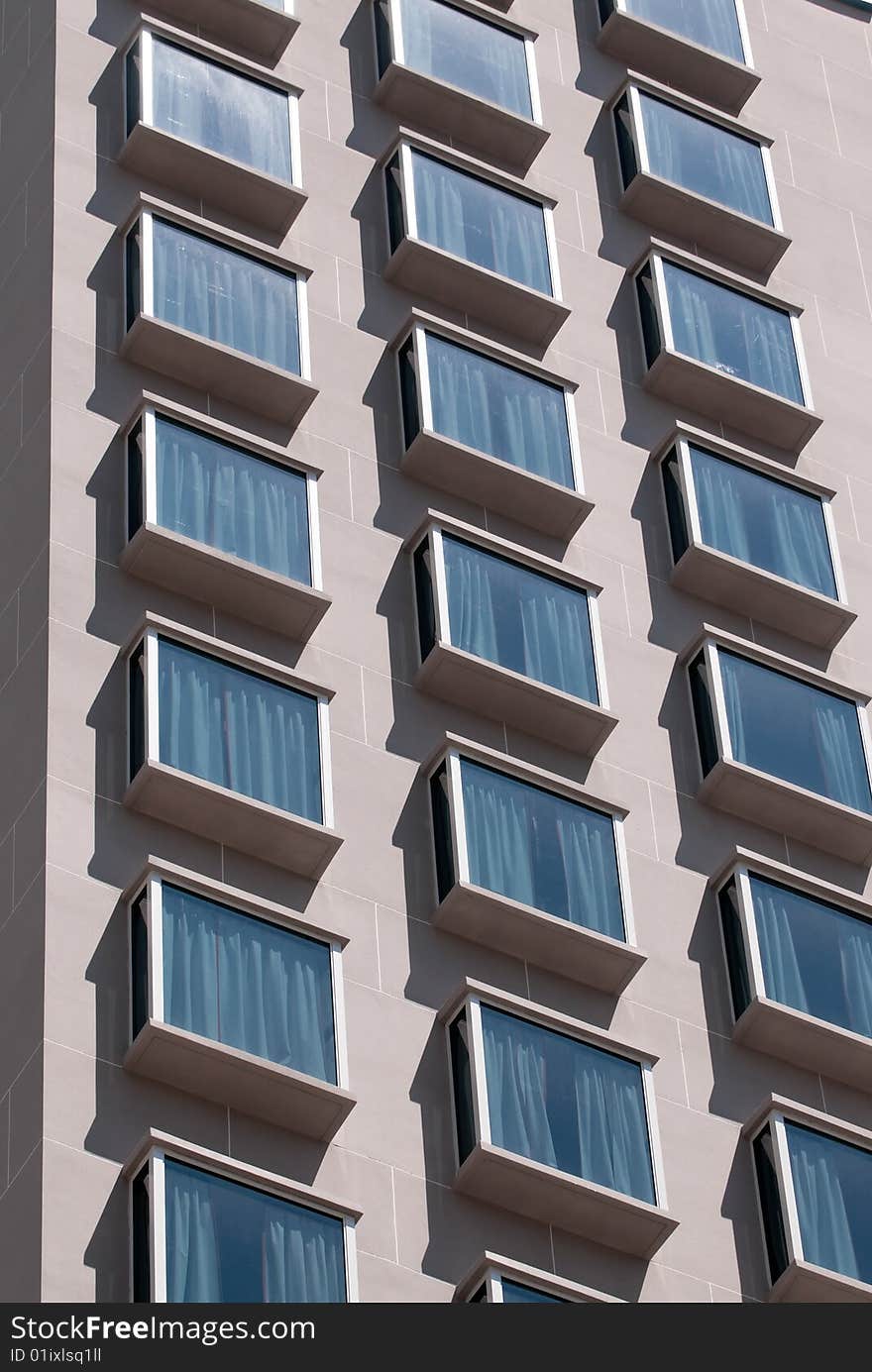 Columns of overhanging windows making the facade of a hotel in modern style architecture. Columns of overhanging windows making the facade of a hotel in modern style architecture