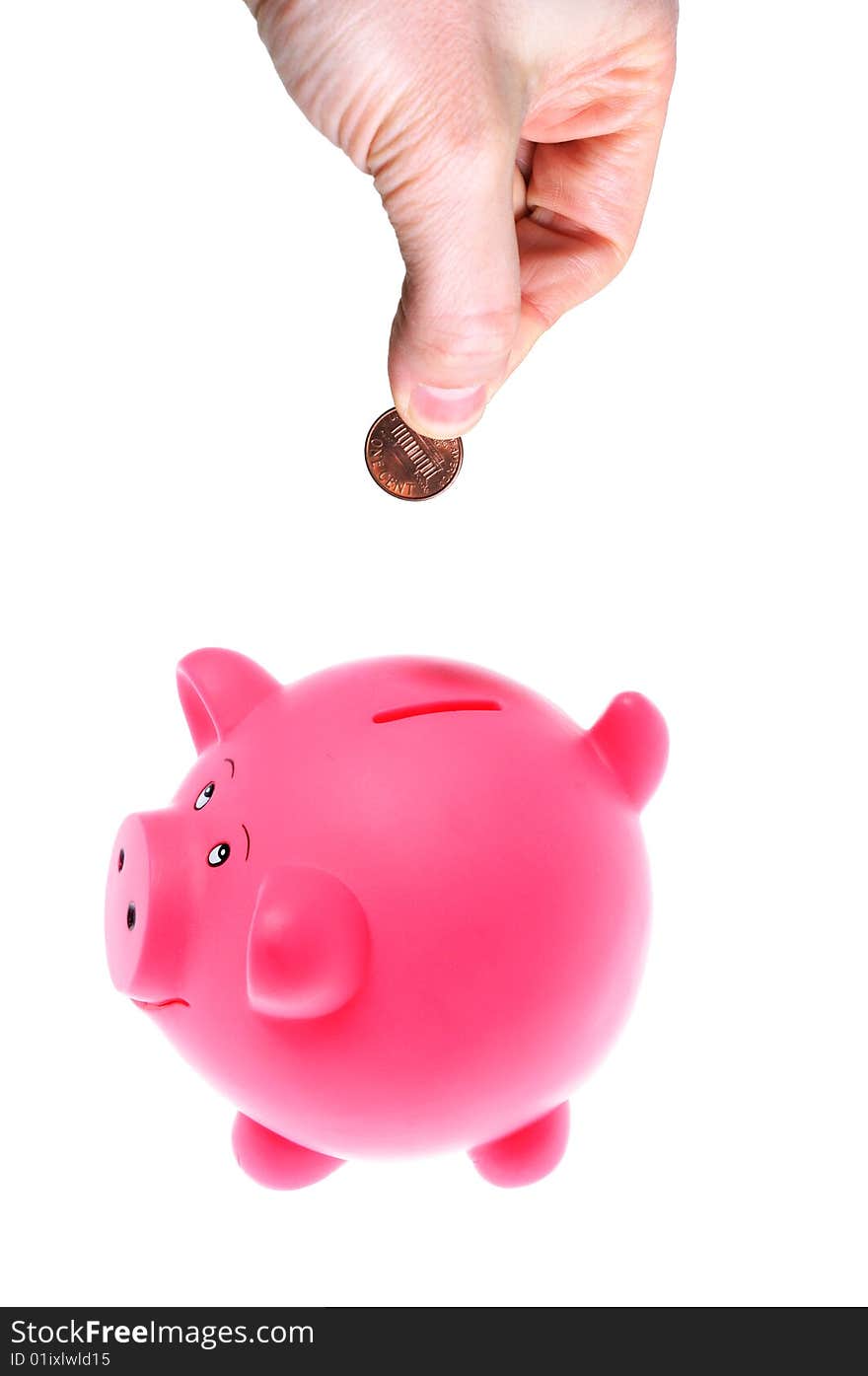 Hand inserting coin into piggy bank isolated on white