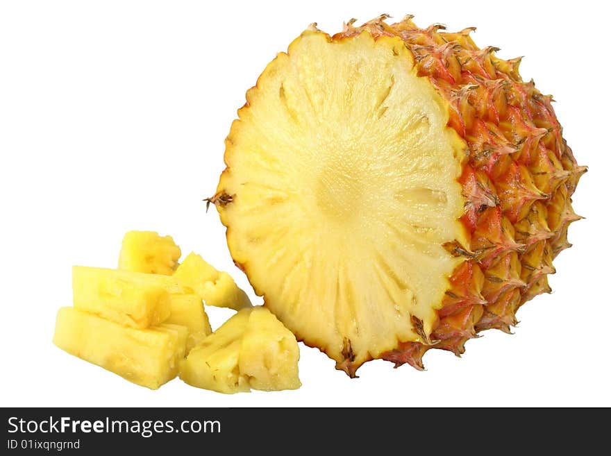 Yellow ripe pineapple with skin on and small pieces in the front on white background